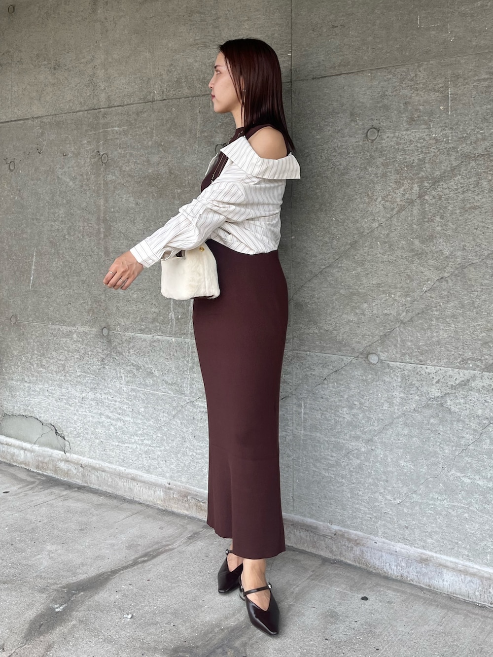 ブラウン系のパンプス、ホワイト系のハンドバッグ、ブラウン系のワンピースを着用したレディースの秋コーディネートの2枚目の写真