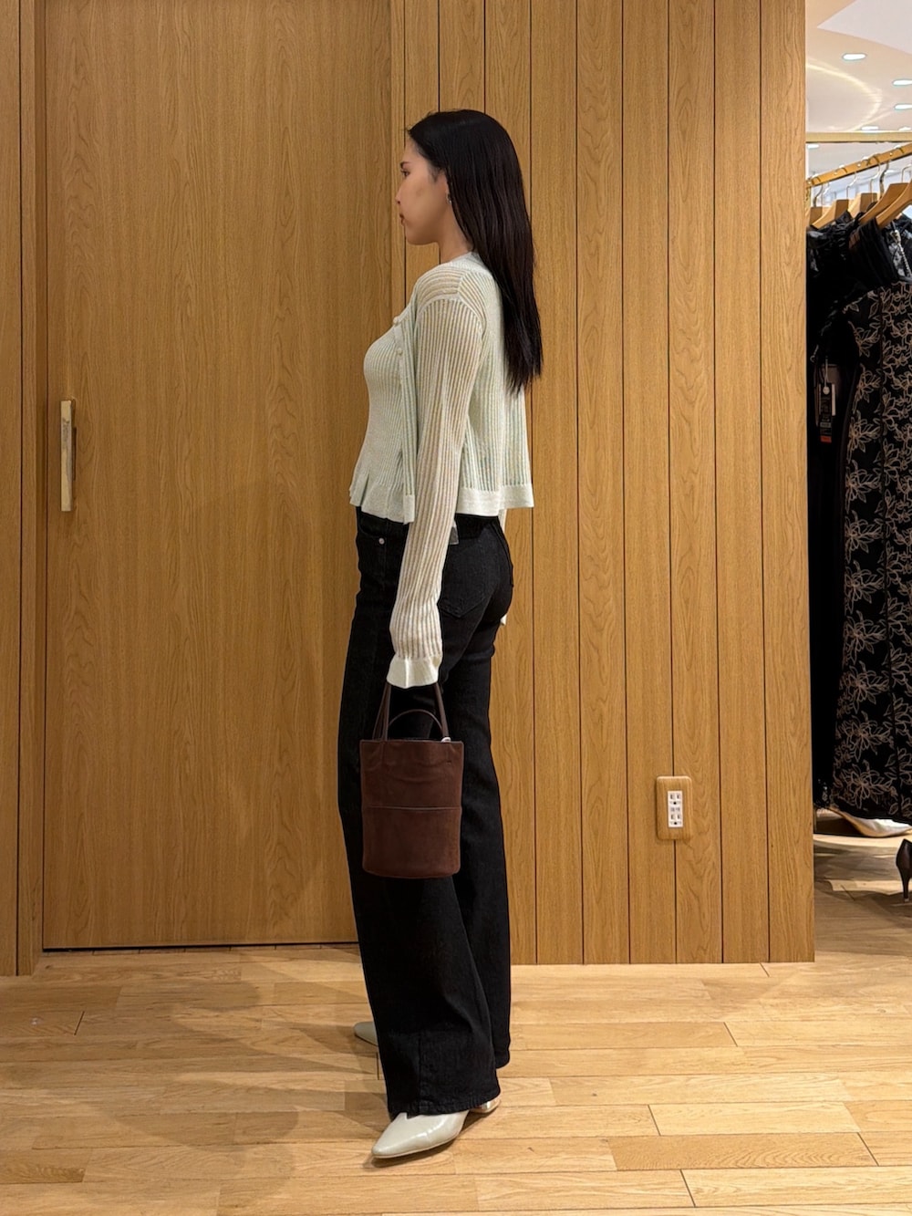 ブラック系のデニムパンツ、ブラウン系のハンドバッグ、グリーン系のパンプスを着用したレディースの夏コーディネートの5枚目の写真