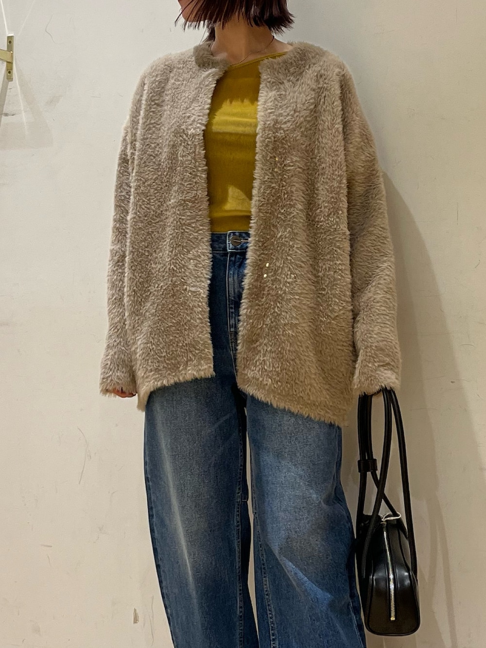 ブラック系のショルダーバッグ、ブラウン系のカーディガン/ボレロ、イエロー系のTシャツ/カットソーを着用したレディースの秋コーディネートの6枚目の写真