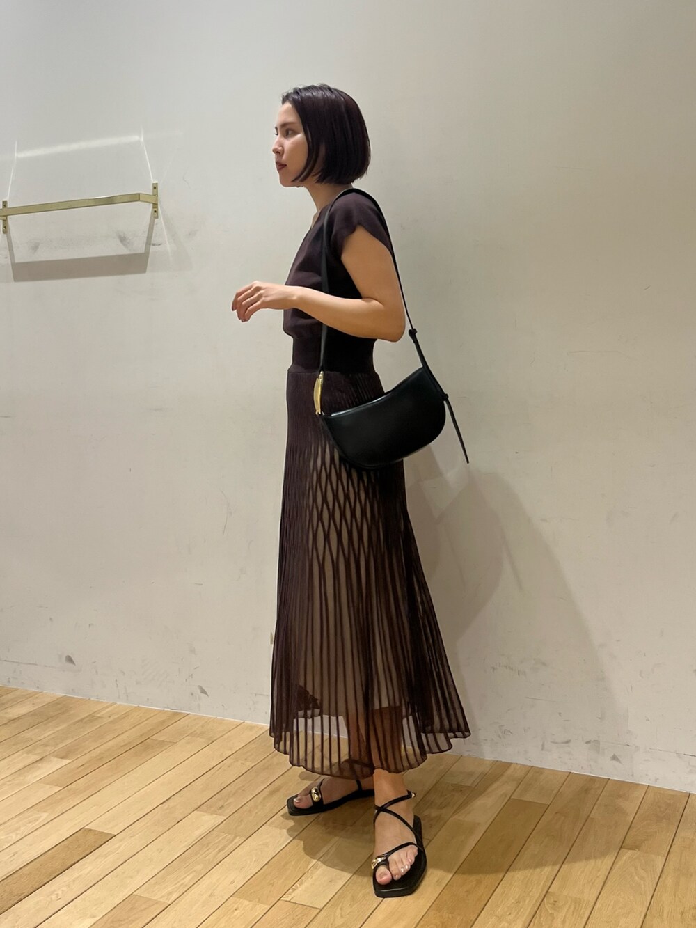 ブラック系のサンダル、ブラウン系のワンピース、ブラック系のショルダーバッグを着用したレディースの夏コーディネートの2枚目の写真