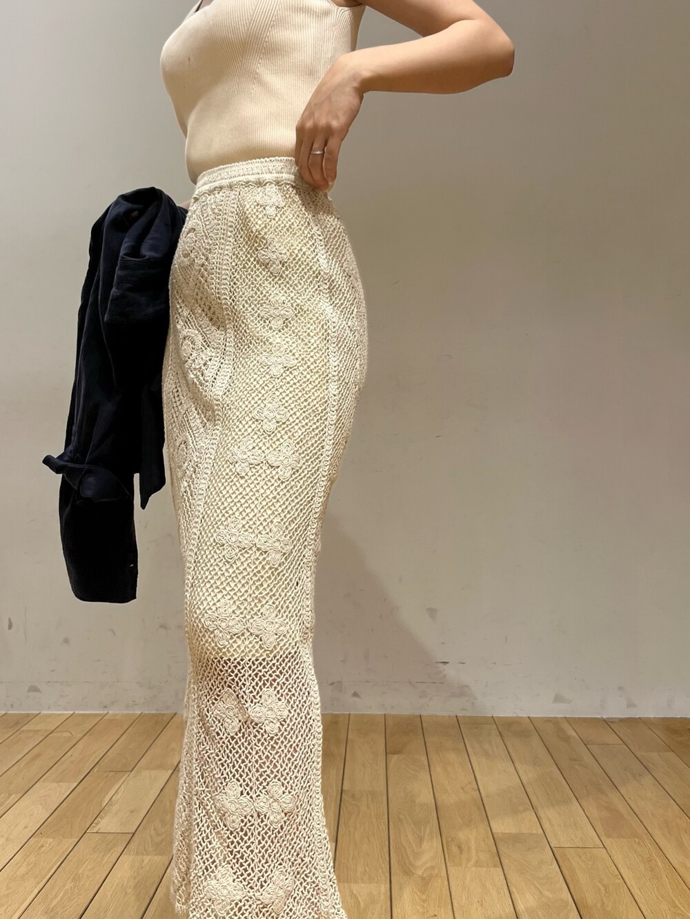 ホワイト系のニット/セーター、ホワイト系のショルダーバッグ、ブルー系のシャツ/ブラウスを着用したレディースの春コーディネートの4枚目の写真