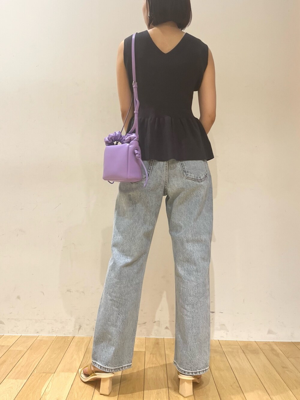 ブルー系のデニムパンツ、パープル系のハンドバッグ、グレー系のニット/セーターを着用したレディースの夏コーディネートの3枚目の写真