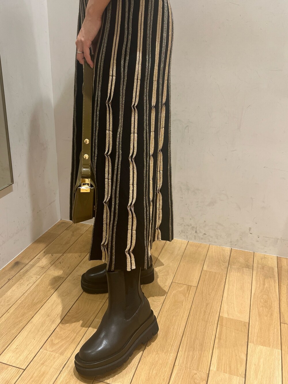 ブラック系のワンピース、ブラウン系のショルダーバッグ、ブラック系のダウンジャケット/コートを着用したレディースの秋コーディネートの7枚目の写真