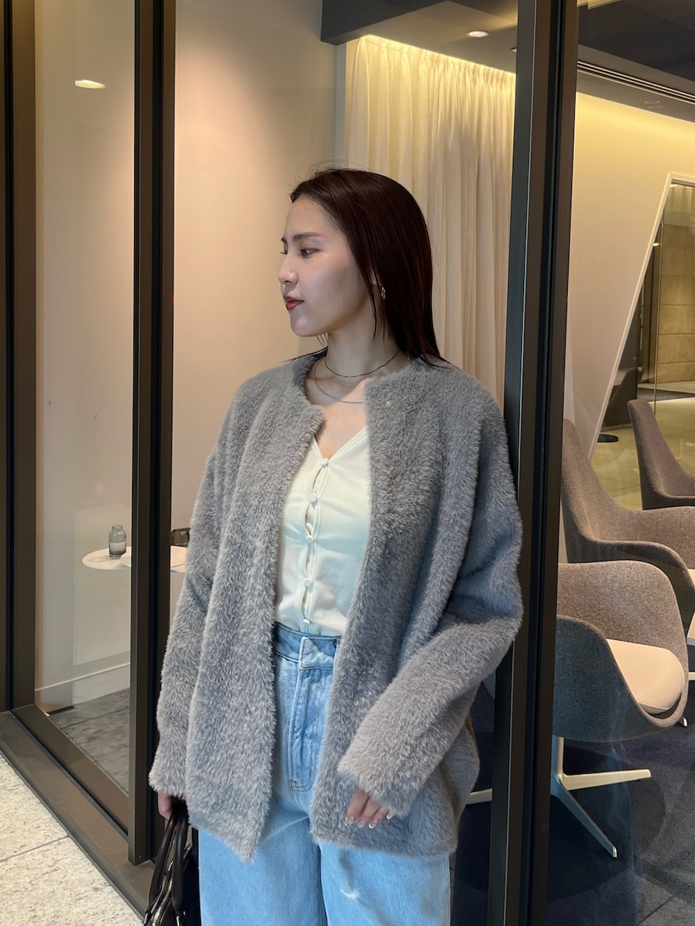 ブルー系のデニムパンツ、ホワイト系のTシャツ/カットソー、ブラウン系のボストンバッグを着用したレディースの夏コーディネートの4枚目の写真