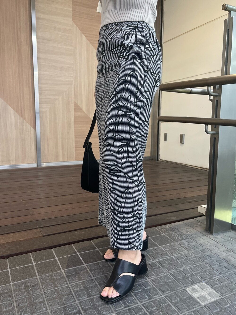 ブラック系のハンドバッグ、ブラック系のサンダル、ブラック系のスカートを着用したレディースの春コーディネートの5枚目の写真