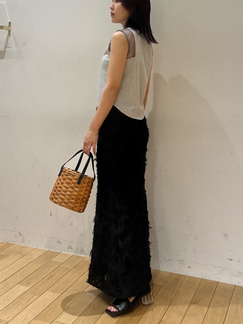 ブラック系のスカート、グレー系のTシャツ/カットソー、ブラウン系のハンドバッグを着用したレディースの夏コーディネートの2枚目の写真