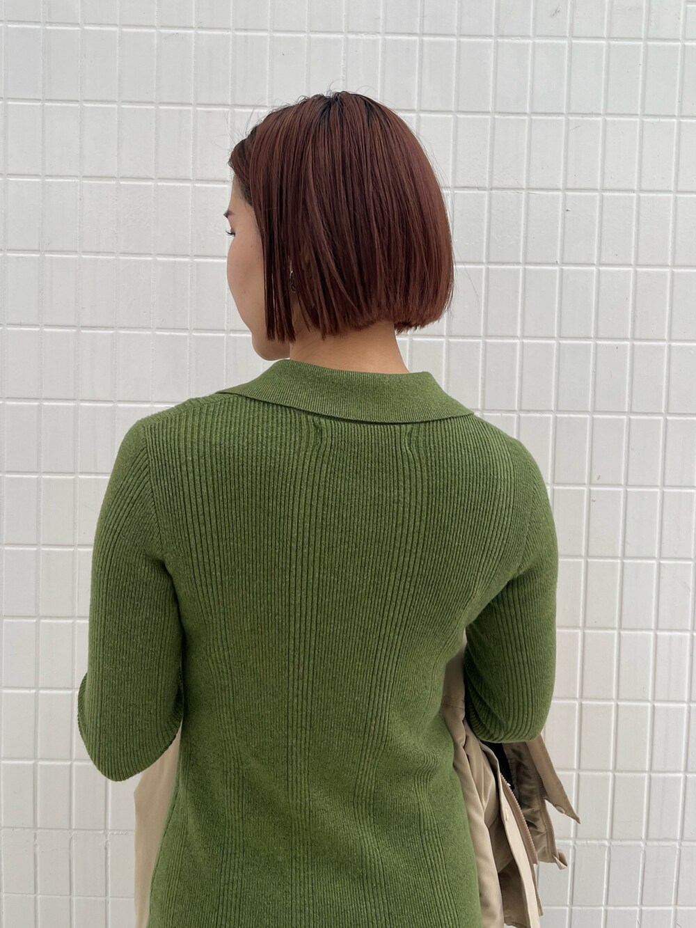 ブラック系のブーツ、ブラック系のハンドバッグ、グリーン系のワンピースを着用したレディースの冬コーディネートの5枚目の写真