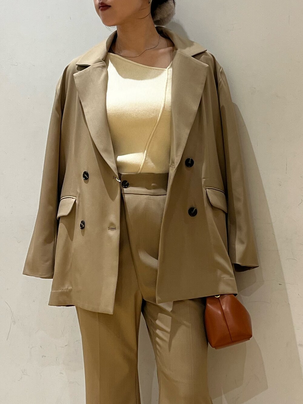 ブラック系のブーツ、ベージュ系のテーラードジャケット、ホワイト系のニット/セーターを着用したレディースの秋コーディネートの5枚目の写真