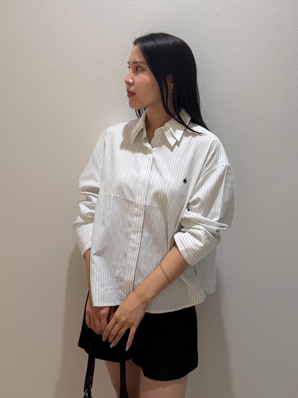 ブラック系のその他パンツ、ホワイト系のシャツ/ブラウス、ブラック系のブーツを着用したレディースの秋コーディネートの4枚目の写真