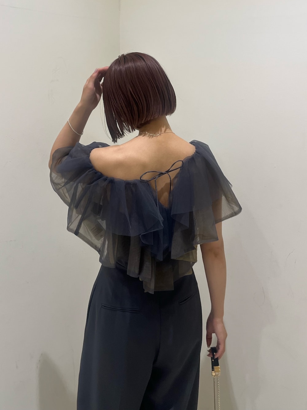 ブラック系のパンプス、ブラック系のクラッチバッグ、グレー系のパンツドレスを着用したレディースの夏コーディネートの6枚目の写真