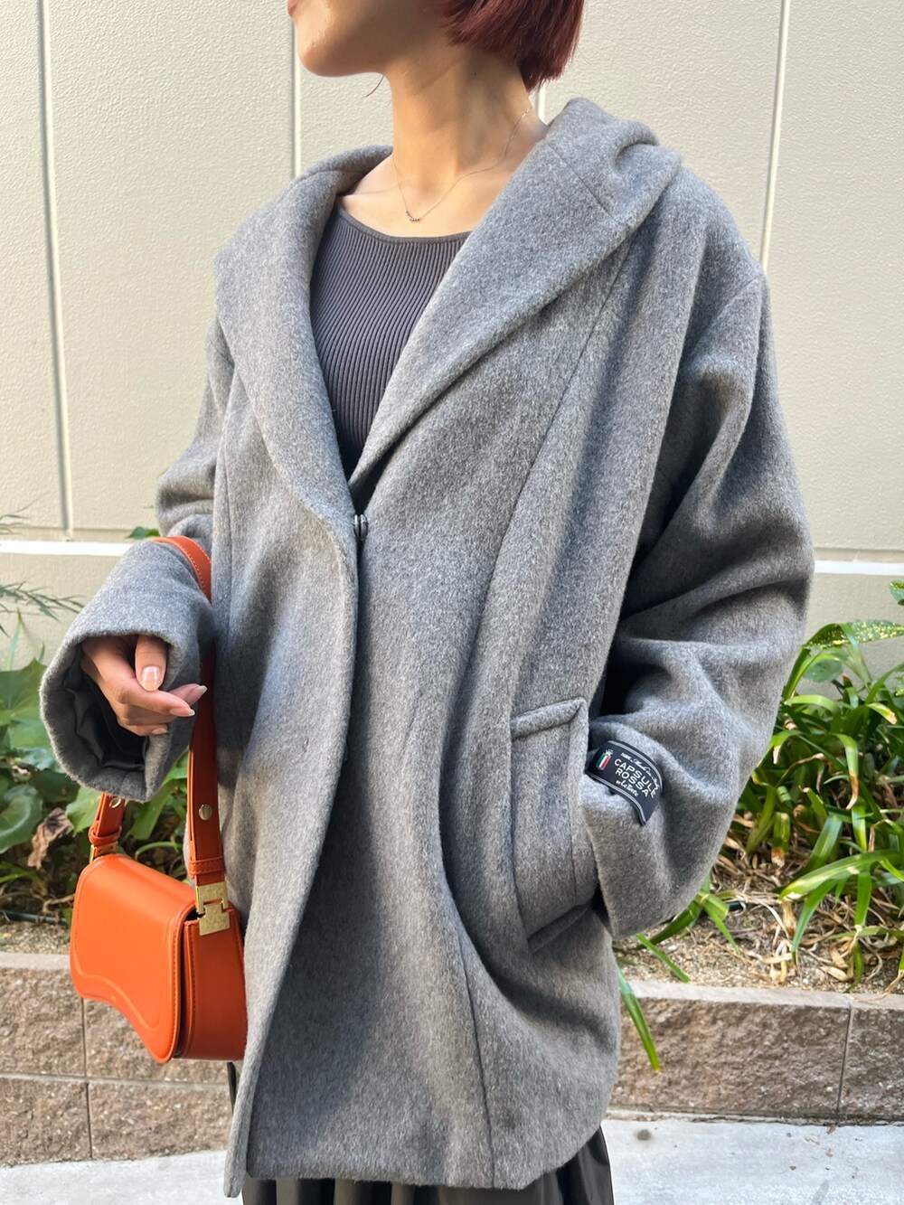 グレー系のワンピース、オレンジ系のショルダーバッグ、グレー系のその他アウターを着用したレディースの秋コーディネートの3枚目の写真