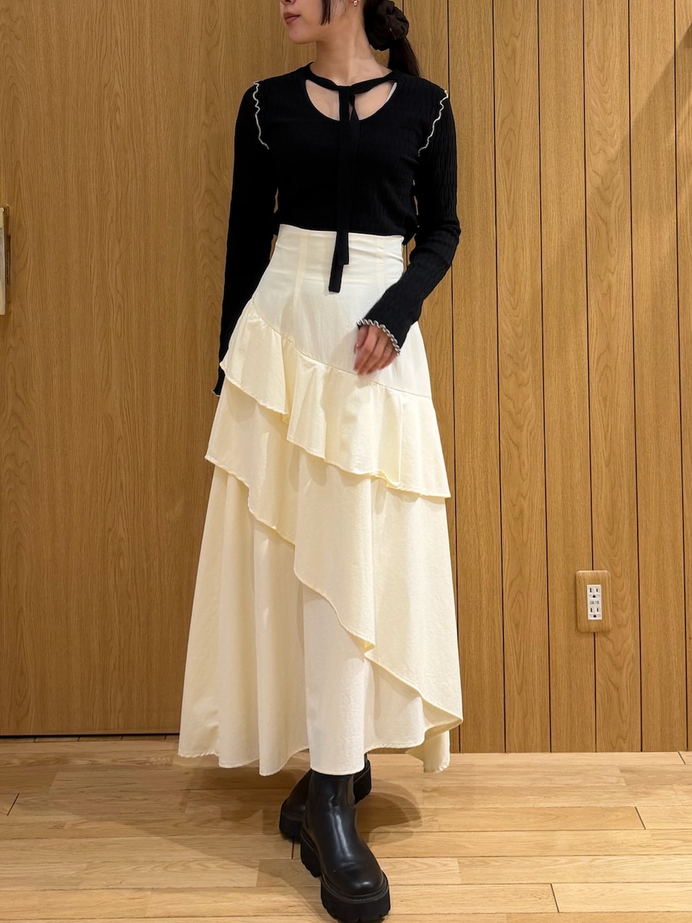 ブラック系のテーラードジャケット、ホワイト系のスカート、ブラック系のニット/セーターを着用したレディースの春コーディネートの3枚目の写真