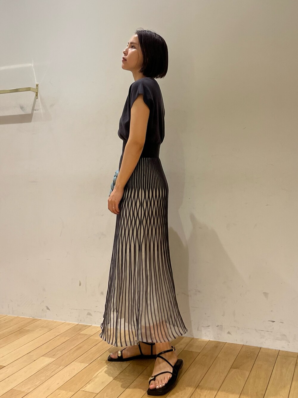 ブラック系のサンダル、グレー系のワンピース、ブルー系のハンドバッグを着用したレディースの夏コーディネートの2枚目の写真