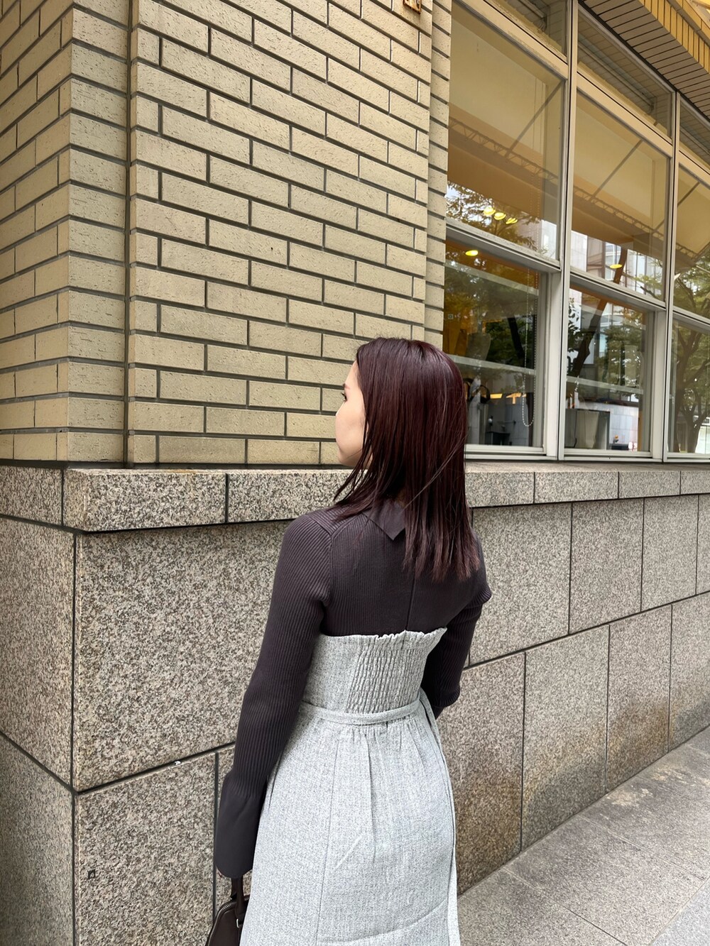 グレー系のワンピース、ブラウン系のボストンバッグ、ブラック系のブーツを着用したレディースの秋コーディネートの6枚目の写真