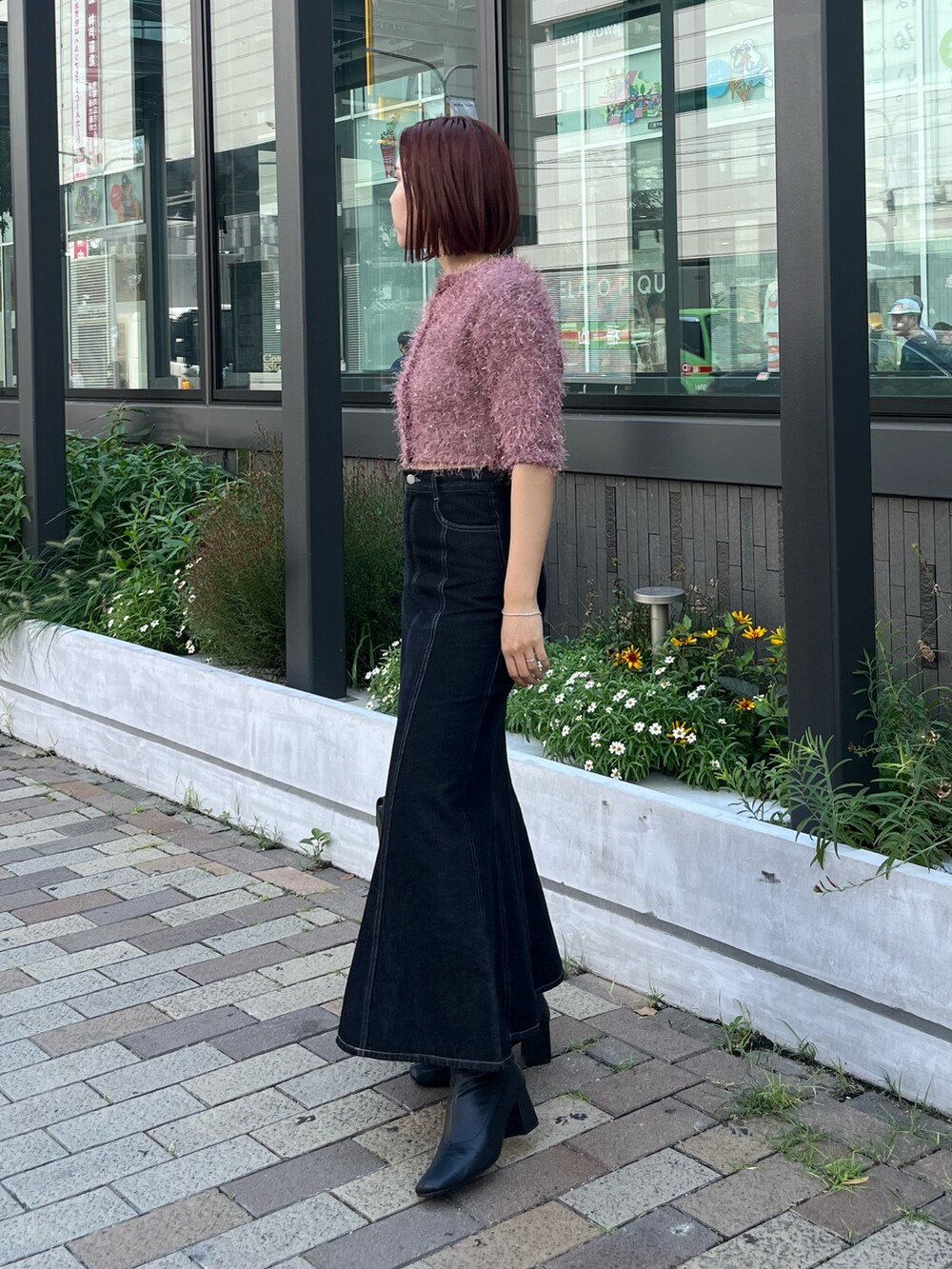 ブラック系のデニムスカート、ピンク系のカーディガン/ボレロ、ブラック系のショルダーバッグを着用したレディースの秋コーディネートの2枚目の写真