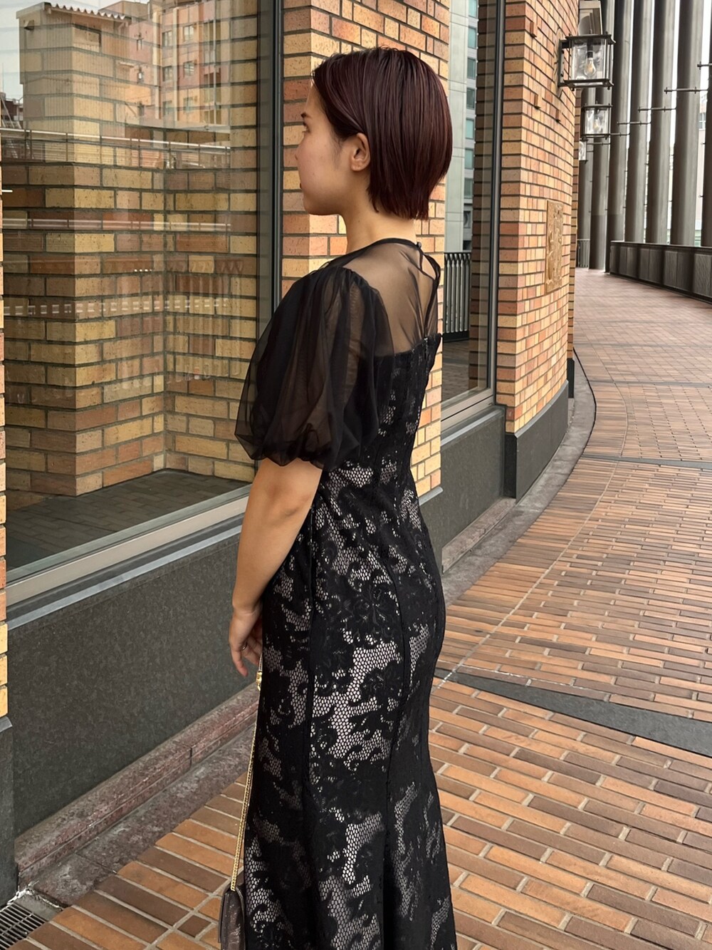 ブラック系のドレス、その他のパンプス、シルバー系のハンドバッグを着用したレディースの冬コーディネートの6枚目の写真