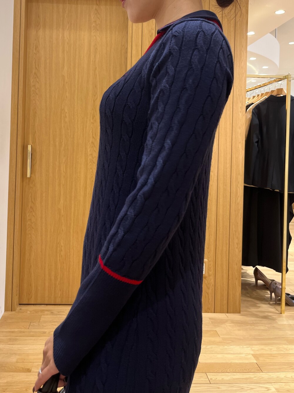 ブルー系のワンピース、ブラウン系のボストンバッグ、ブラウン系のパンプスを着用したレディースの秋コーディネートの5枚目の写真