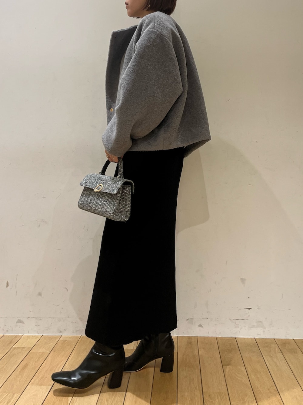 ブラック系のブーツ、グレー系のブルゾン、ブラック系のワンピースを着用したレディースの冬コーディネートの2枚目の写真