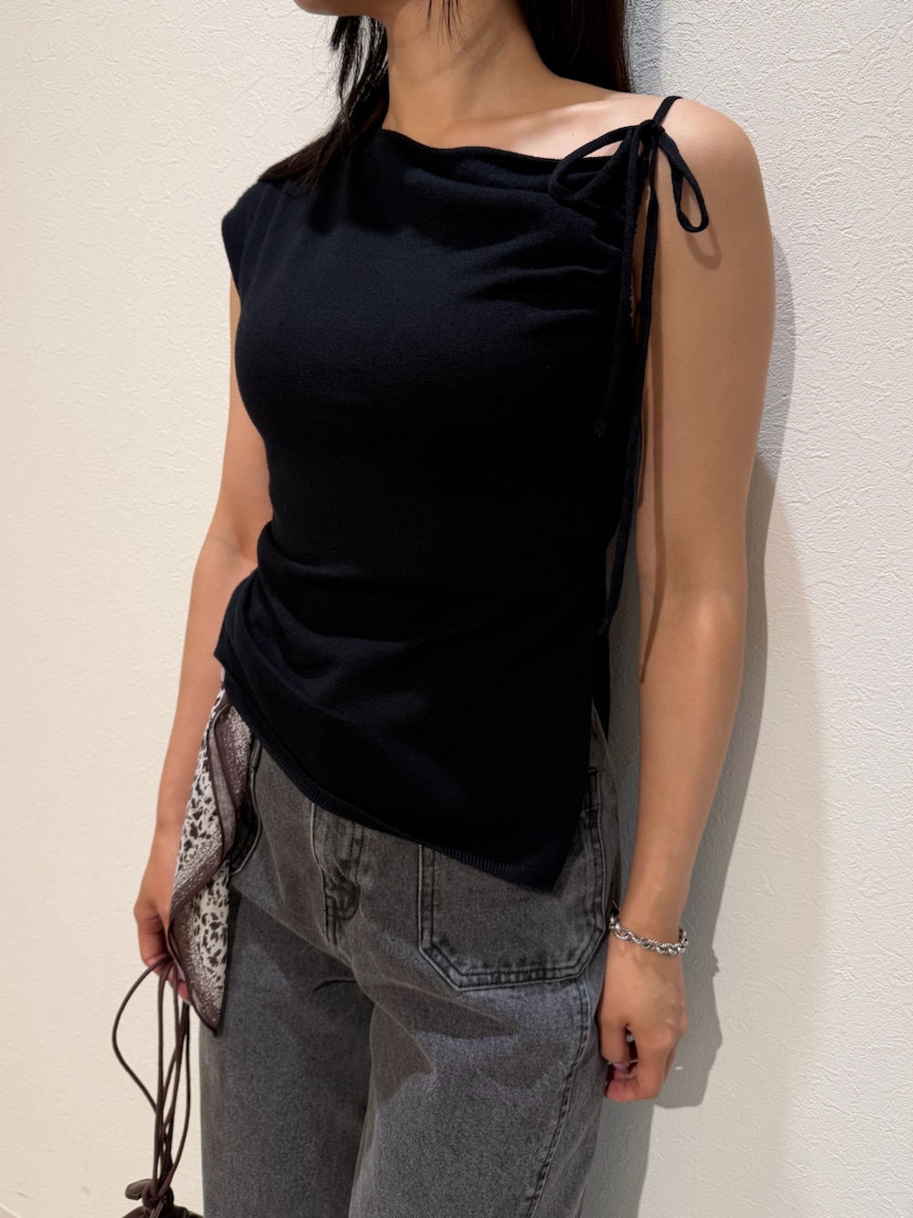ブラック系のパンプス、ブラウン系のハンドバッグ、ブラック系のデニムパンツを着用したレディースの夏コーディネートの7枚目の写真