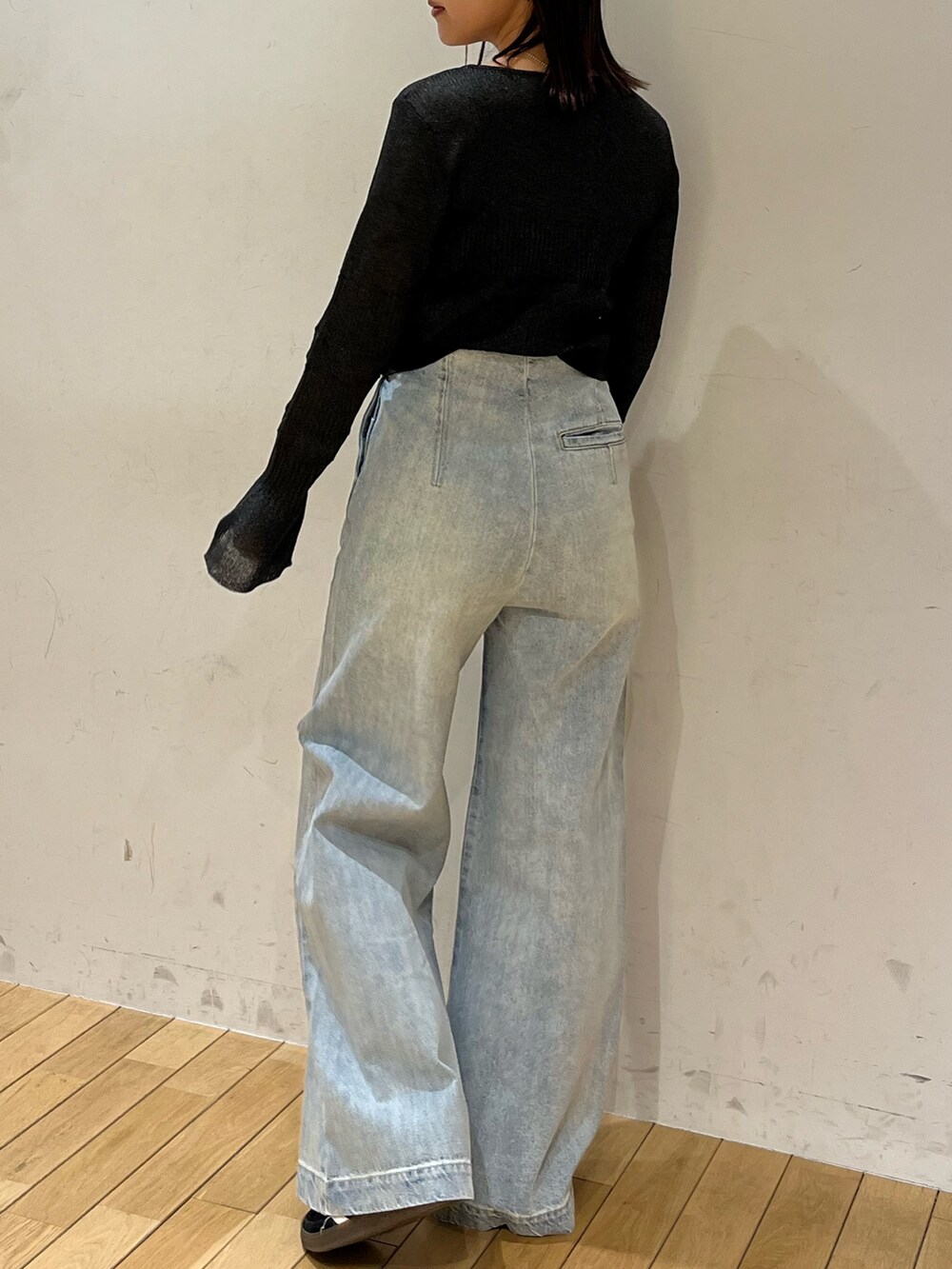 ブルー系のデニムパンツ、ブラック系のスニーカー、ブラック系のカーディガン/ボレロを着用したレディースの春コーディネートの3枚目の写真