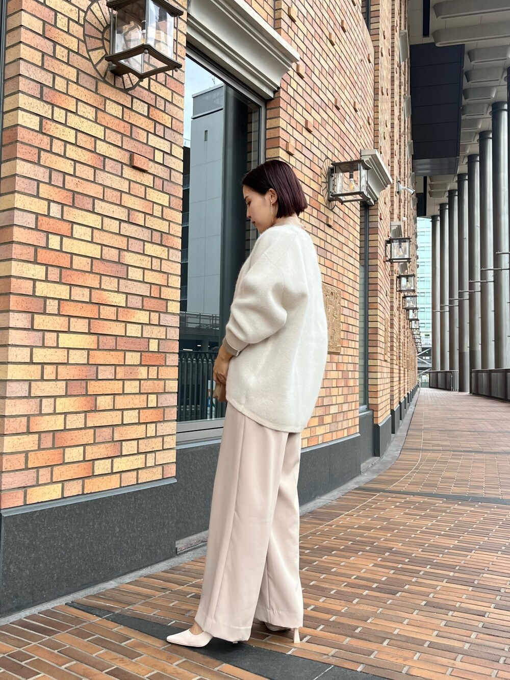 ホワイト系のカーディガン/ボレロ、ベージュ系のパンツドレス、ブラウン系のパンプスを着用したレディースの秋コーディネートの3枚目の写真