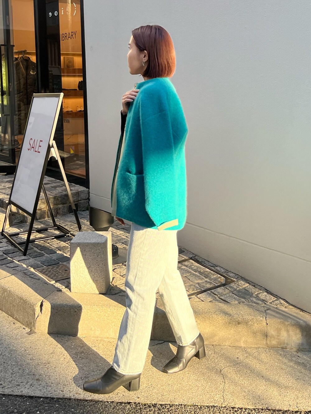 ブルー系のデニムパンツ、ブルー系のカーディガン/ボレロ、ブラック系のニット/セーターを着用したレディースの冬コーディネートの3枚目の写真