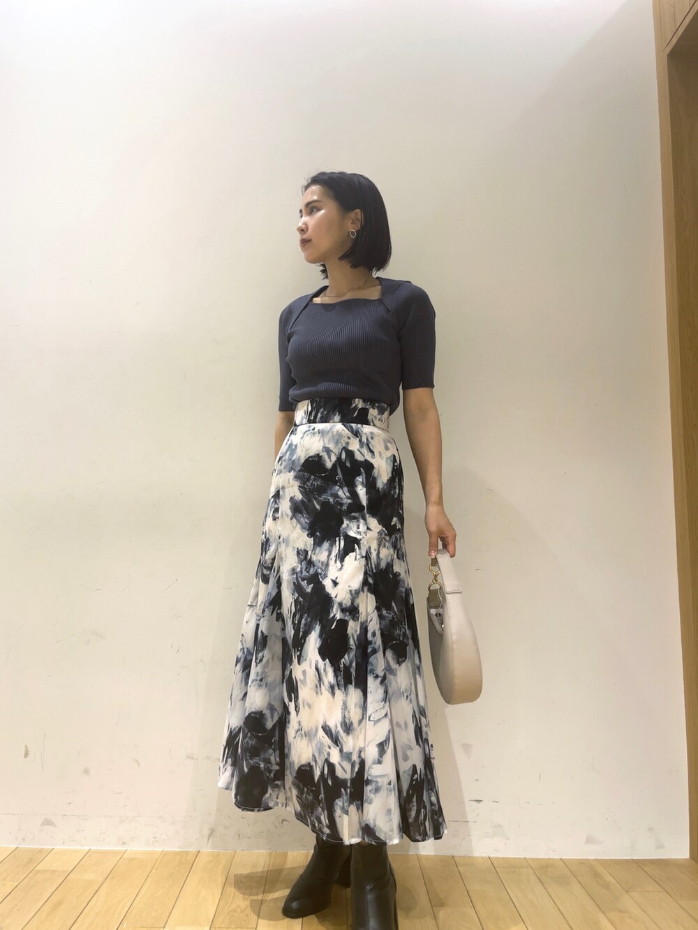 ブルー系のスカート、ブルー系のニット/セーター、グレー系のその他アウターを着用したレディースの夏コーディネートの5枚目の写真