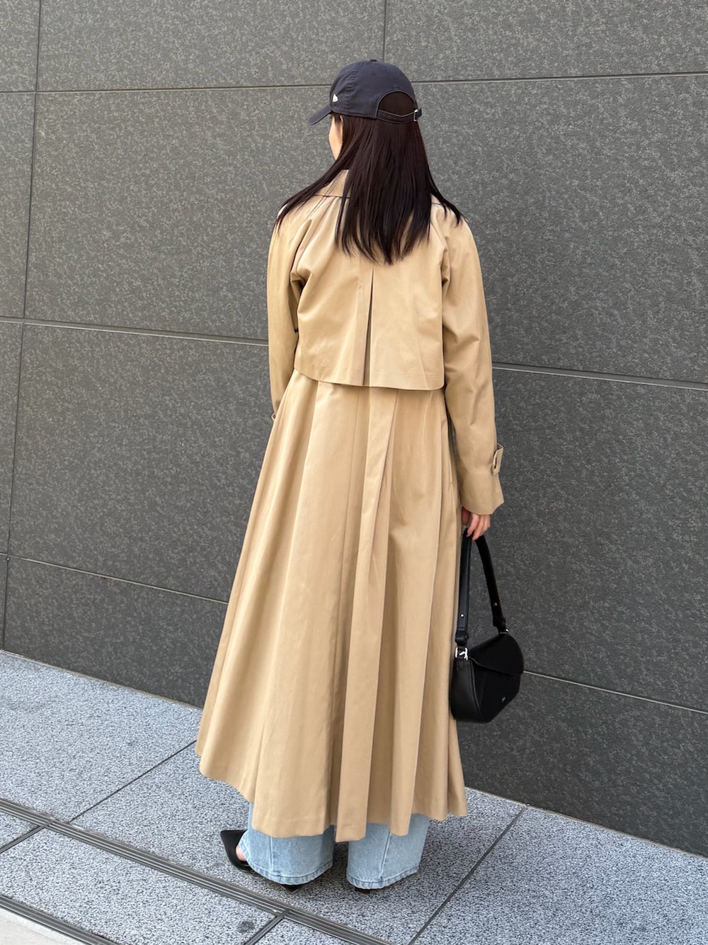 ブラック系のシャツ/ブラウス、ブルー系のデニムパンツ、ベージュ系のトレンチコートを着用したレディースの冬コーディネートの3枚目の写真