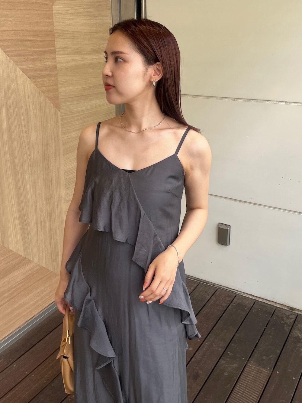 グレー系のワンピース、ブラウン系のハンドバッグ、ブラック系のサンダルを着用したレディースの夏コーディネートの4枚目の写真