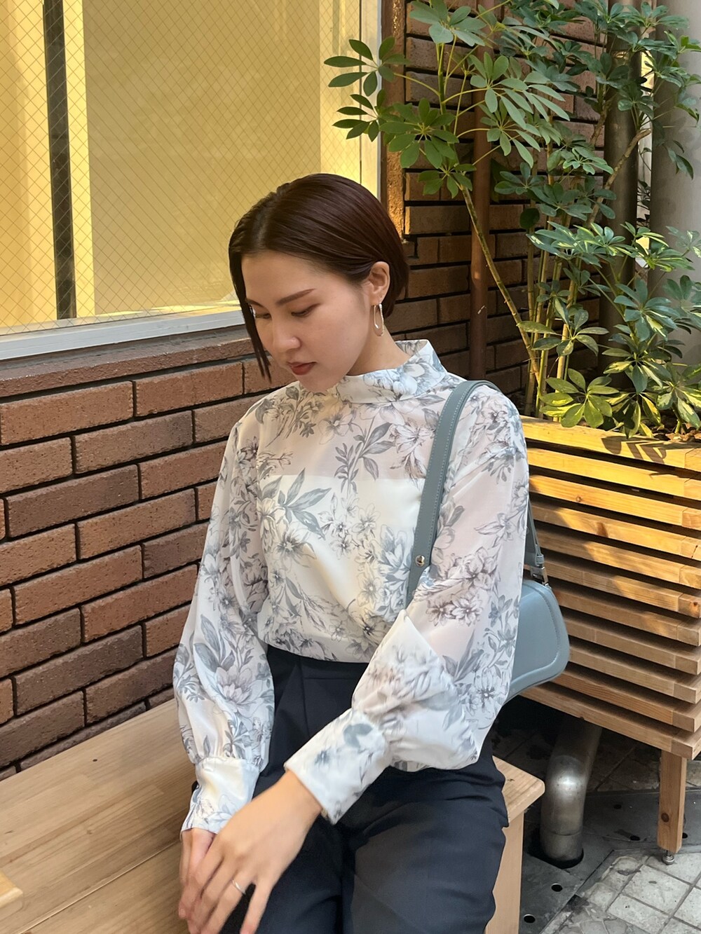 グレー系のシャツ/ブラウス、ブルー系のショルダーバッグ、グレー系のスラックスを着用したレディースの冬コーディネートの4枚目の写真