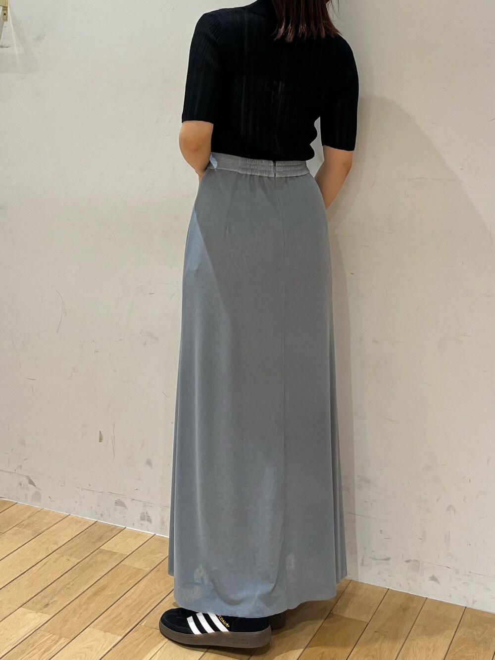 ブルー系のスカート、ブラック系のTシャツ/カットソー、ブラック系のスニーカーを着用したレディースの春コーディネートの3枚目の写真