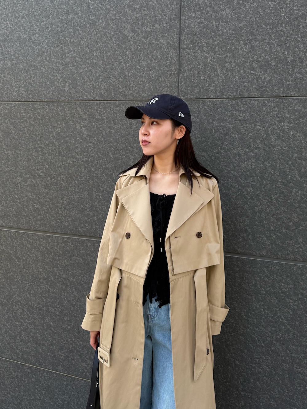 ブラック系のシャツ/ブラウス、ブルー系のデニムパンツ、ベージュ系のトレンチコートを着用したレディースの冬コーディネートの4枚目の写真