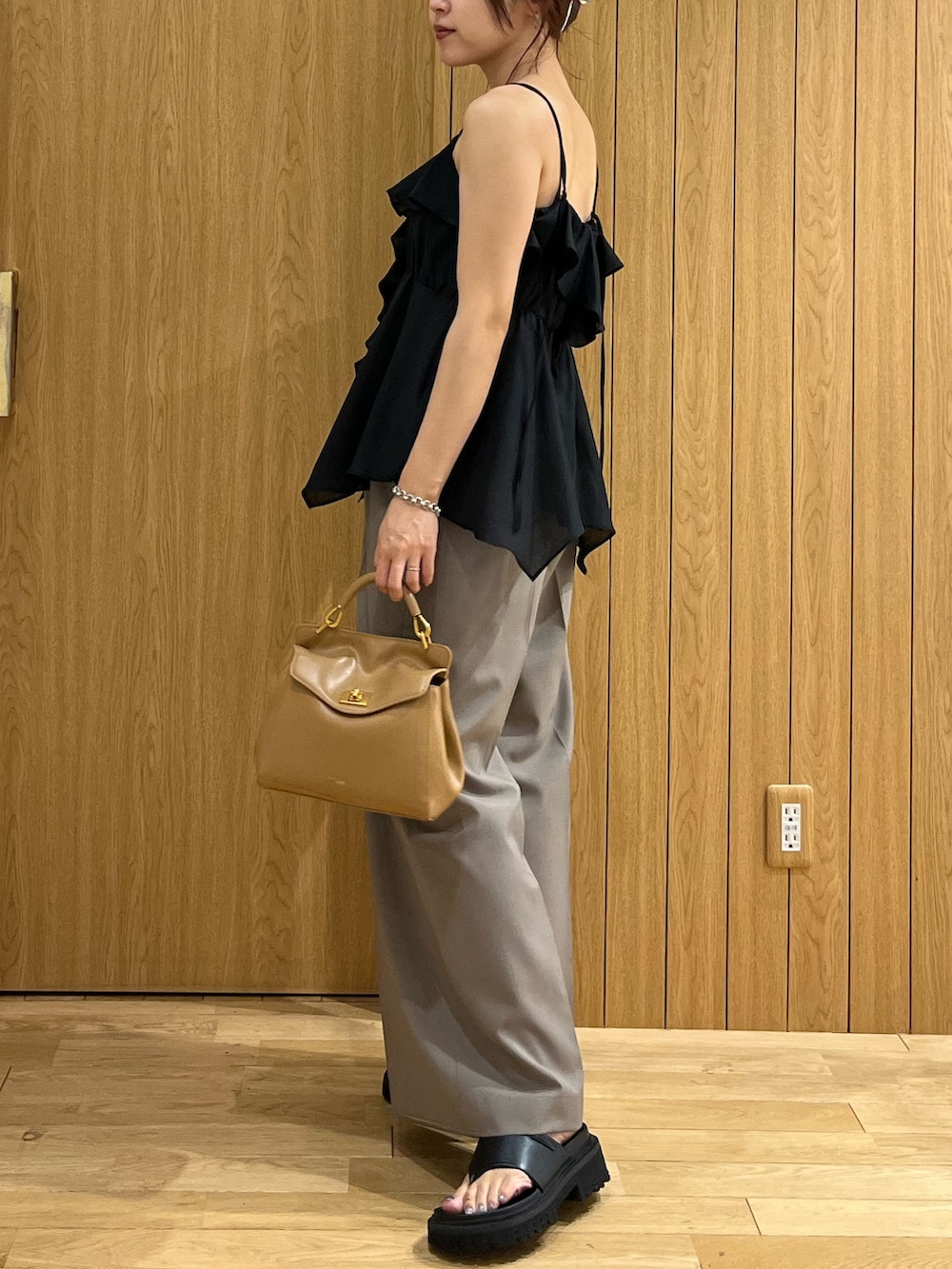 ブラウン系のハンドバッグ、ブラック系のキャミソール、ブラウン系のその他パンツを着用したレディースの夏コーディネートの2枚目の写真