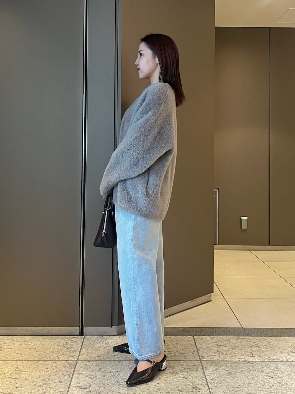 ブルー系のデニムパンツ、ホワイト系のTシャツ/カットソー、ブラウン系のボストンバッグを着用したレディースの夏コーディネートの2枚目の写真