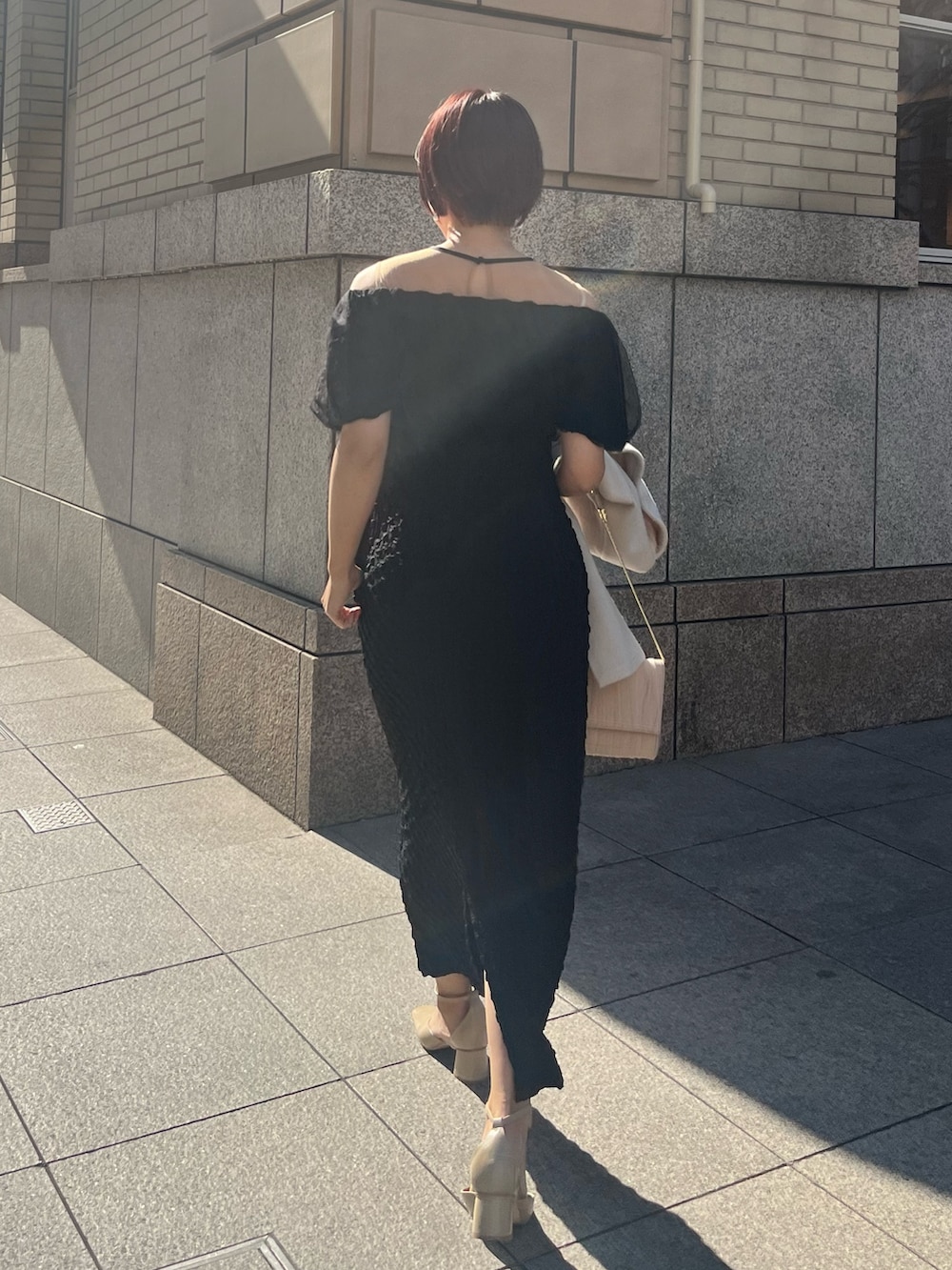 ブラック系のドレス、ベージュ系のパンプスを着用したレディースの冬コーディネートの3枚目の写真