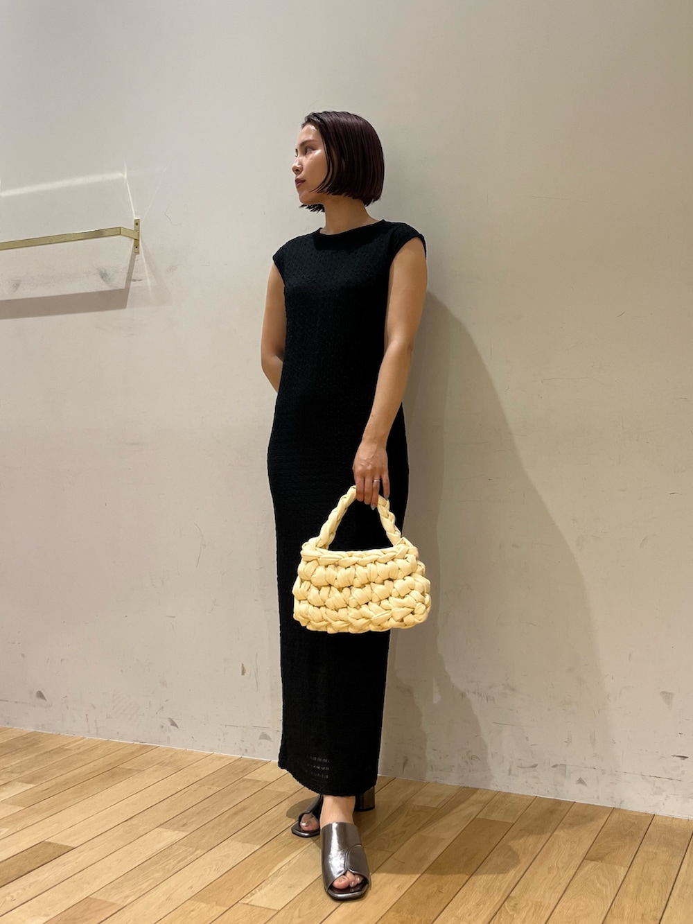 ホワイト系のハンドバッグ、ブラック系のワンピース、その他のサンダルを着用したレディースの夏コーディネートの4枚目の写真