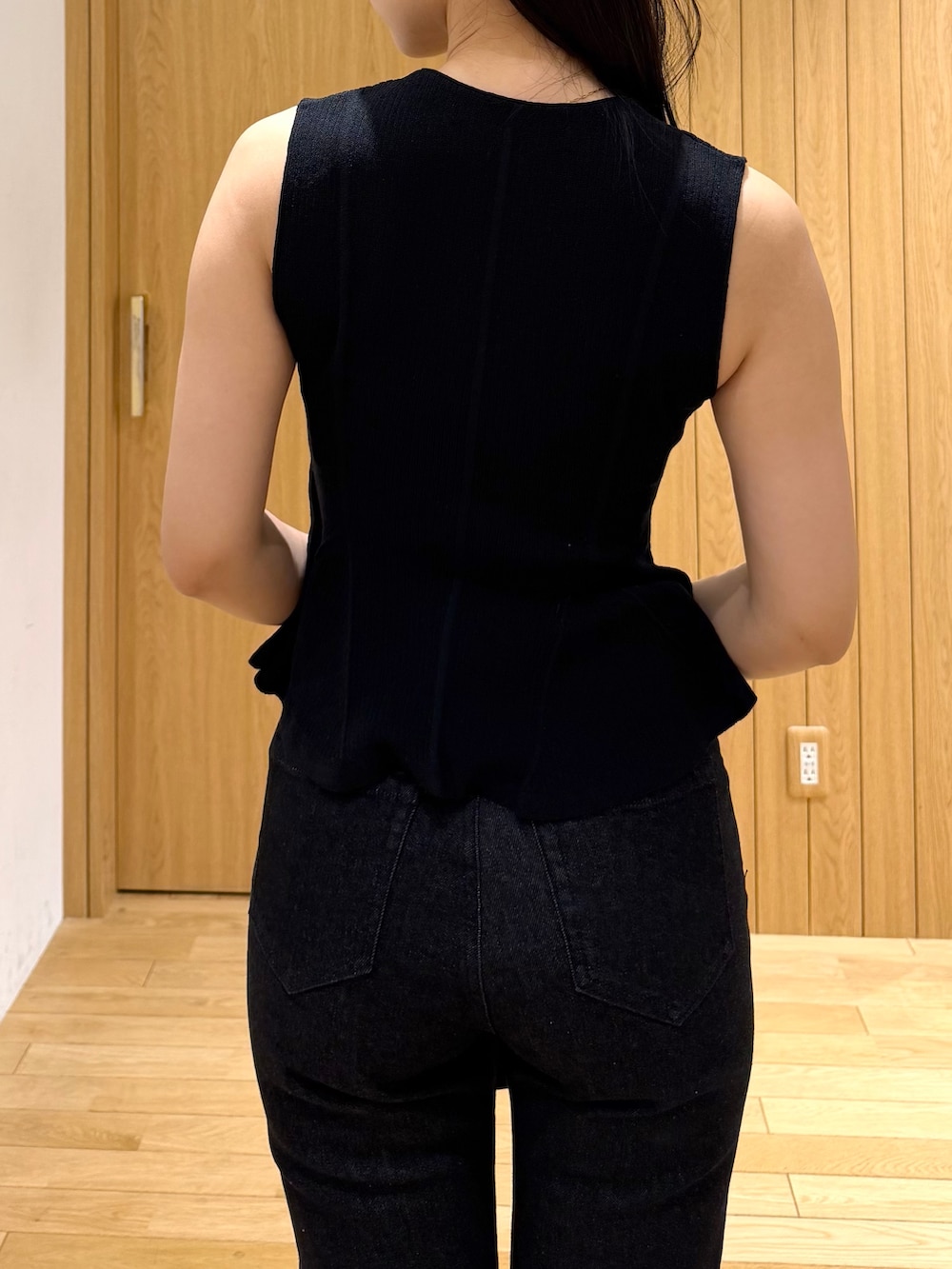 ブラック系のデニムパンツ、ブラック系のニット/セーター、ブラウン系のハンドバッグを着用したレディースの夏コーディネートの5枚目の写真