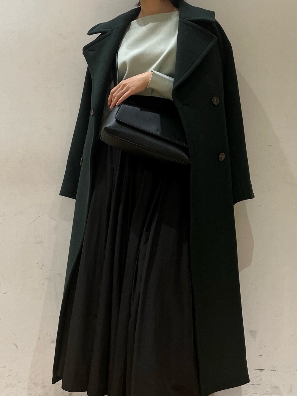 ブラック系のブーツ、グリーン系のニット/セーター、グリーン系のステンカラーコートを着用したレディースの冬コーディネートの6枚目の写真