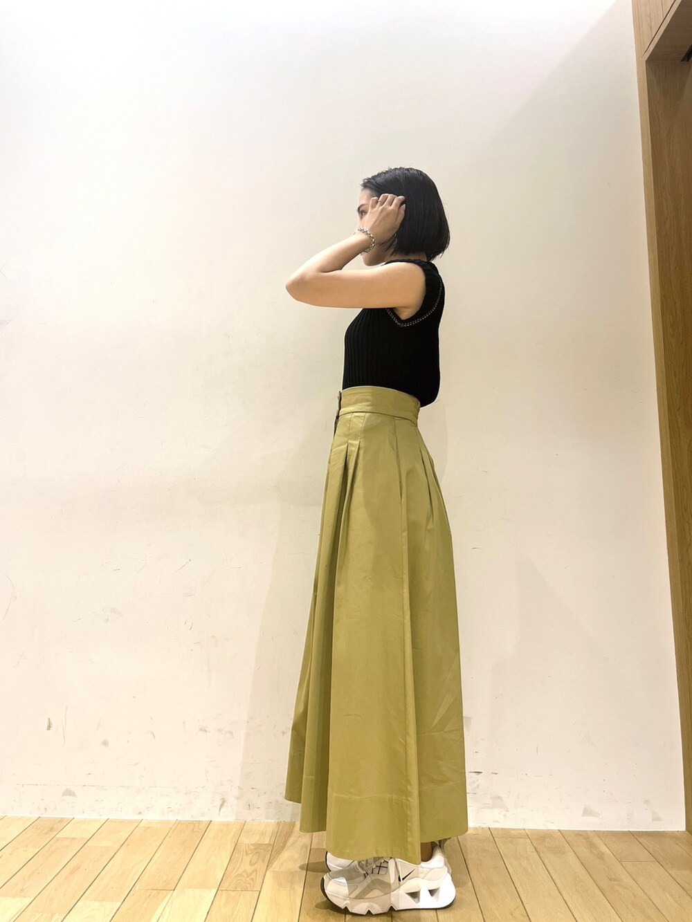 ブラック系のニット/セーター、イエロー系のスカートを着用したレディースの夏コーディネートの2枚目の写真