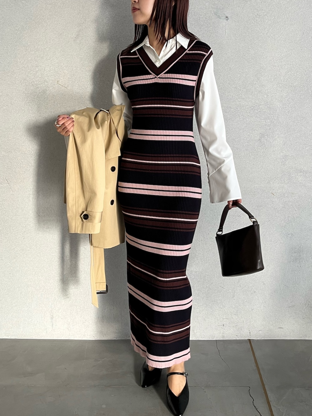 ブラウン系のハンドバッグ、ブラウン系のワンピース、ベージュ系のトレンチコートを着用したレディースの冬コーディネートの8枚目の写真