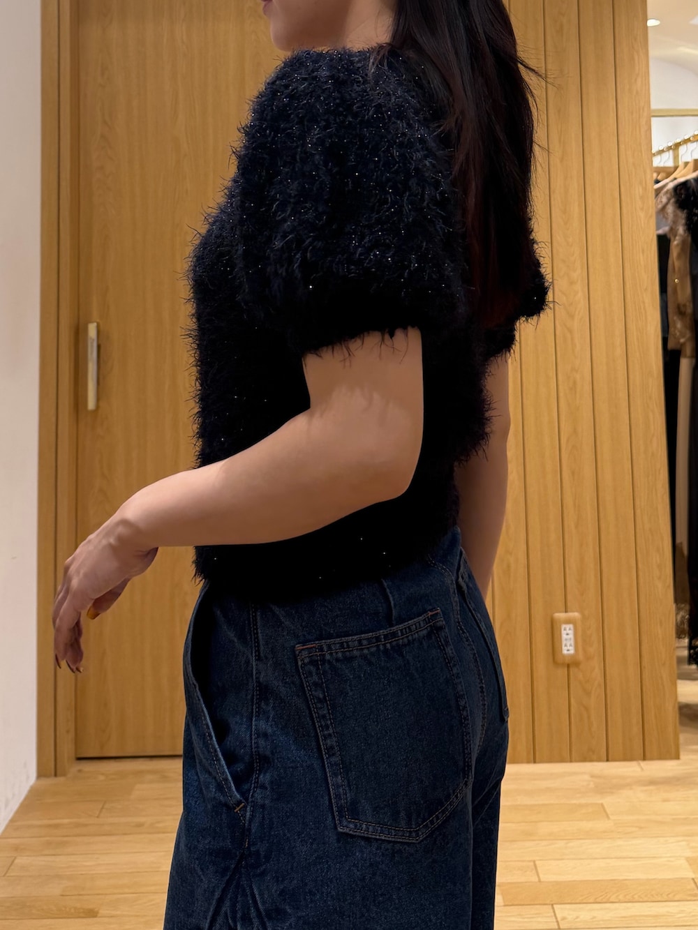 ブルー系のデニムパンツ、ブラック系のニット/セーター、ブラック系のハンドバッグを着用したレディースの秋コーディネートの5枚目の写真