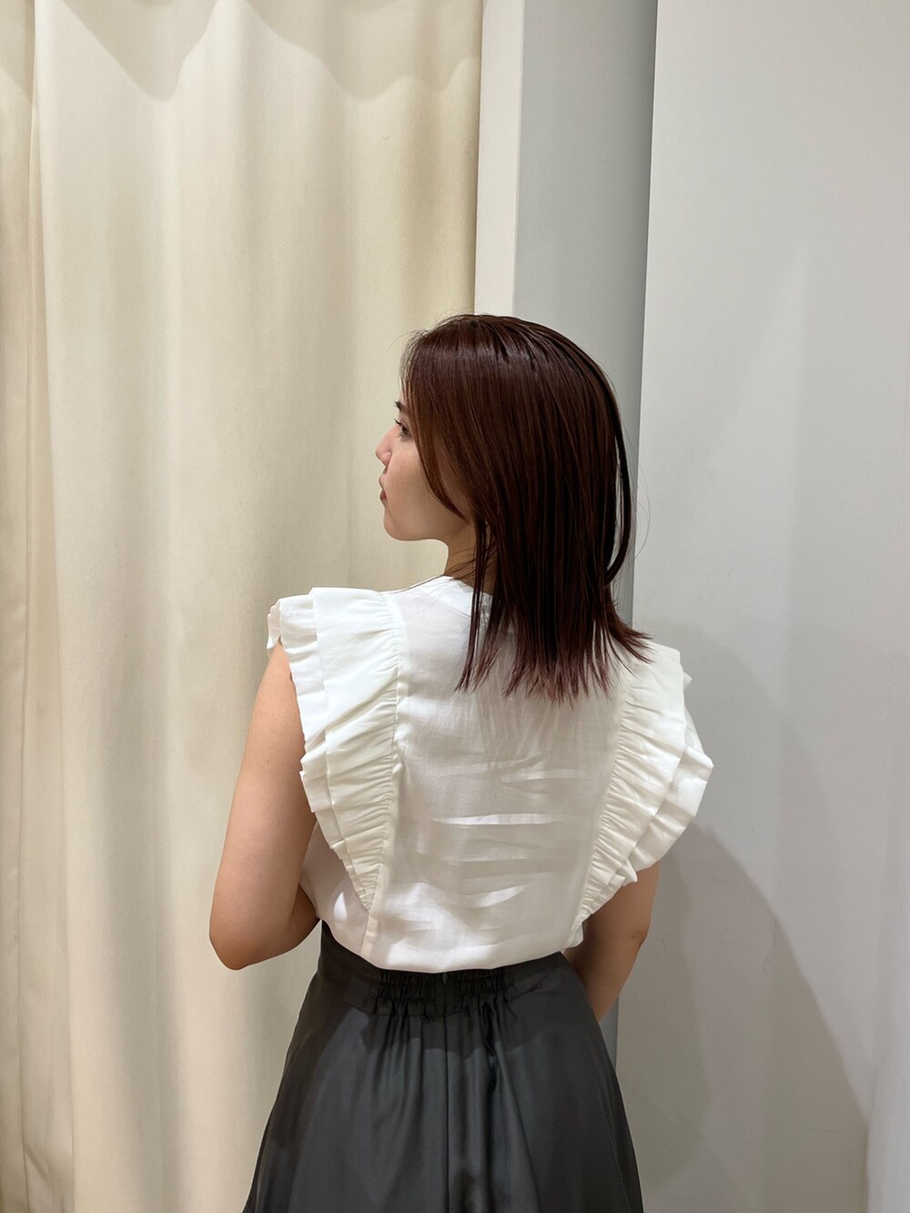 ブラック系のスニーカー、ホワイト系のシャツ/ブラウス、グレー系のスカートを着用したレディースの春コーディネートの6枚目の写真