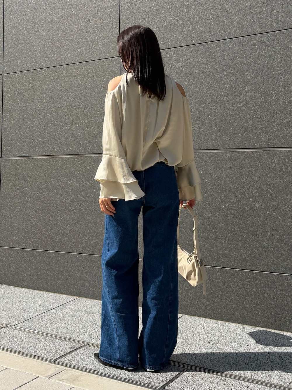 ブルー系のデニムパンツ、グリーン系のシャツ/ブラウス、ブラック系のパンプスを着用したレディースの春コーディネートの3枚目の写真