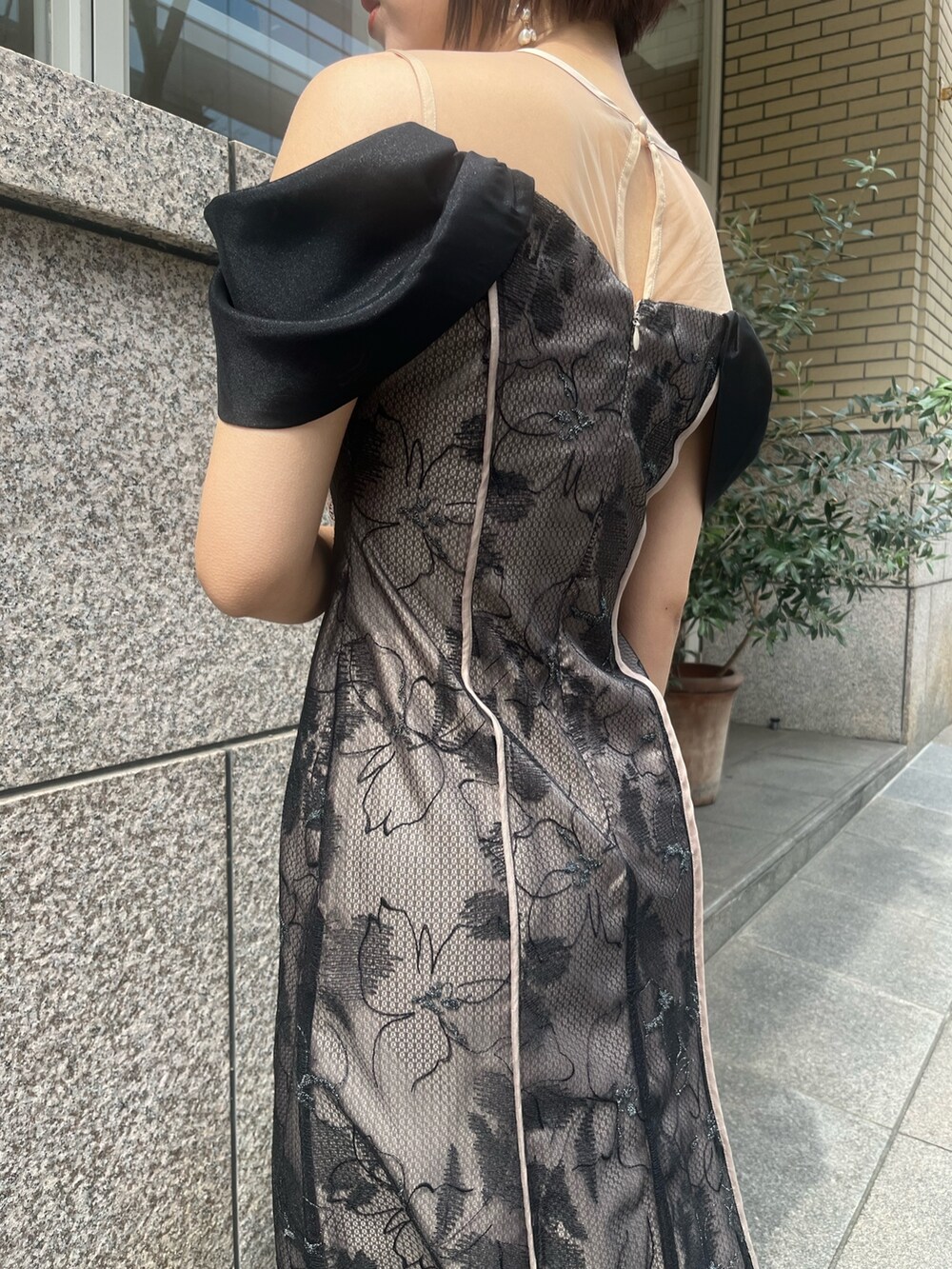 ベージュ系のパンプス、ベージュ系のハンドバッグ、ブラック系のドレスを着用したレディースの春コーディネートの5枚目の写真