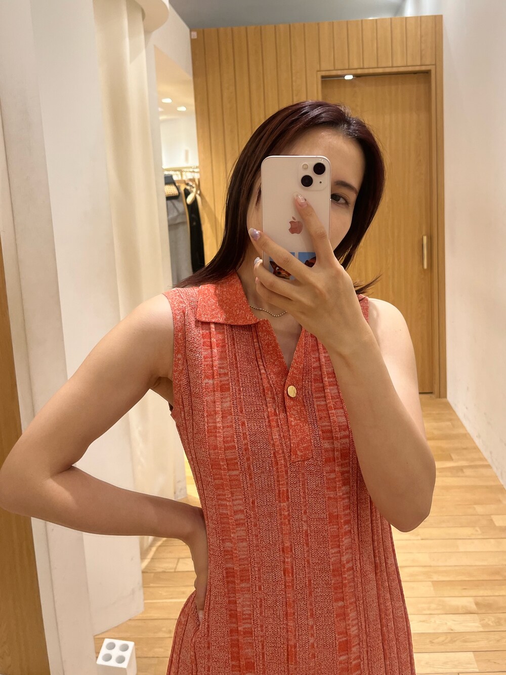 ブラック系のハンドバッグ、ブラック系のサンダル、オレンジ系のワンピースを着用したレディースの夏コーディネートの6枚目の写真