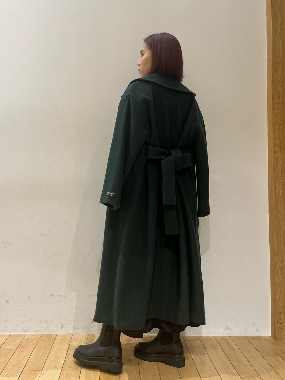 ブラック系のブーツ、グリーン系のニット/セーター、グリーン系のステンカラーコートを着用したレディースの冬コーディネートの4枚目の写真