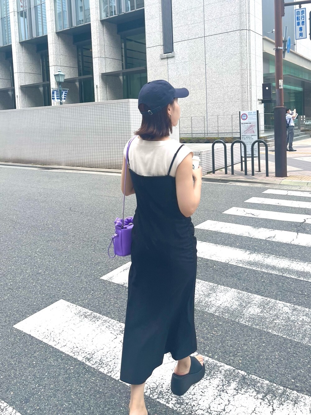 ブラック系のワンピース、ホワイト系のニット/セーター、パープル系のハンドバッグを着用したレディースの夏コーディネートの5枚目の写真
