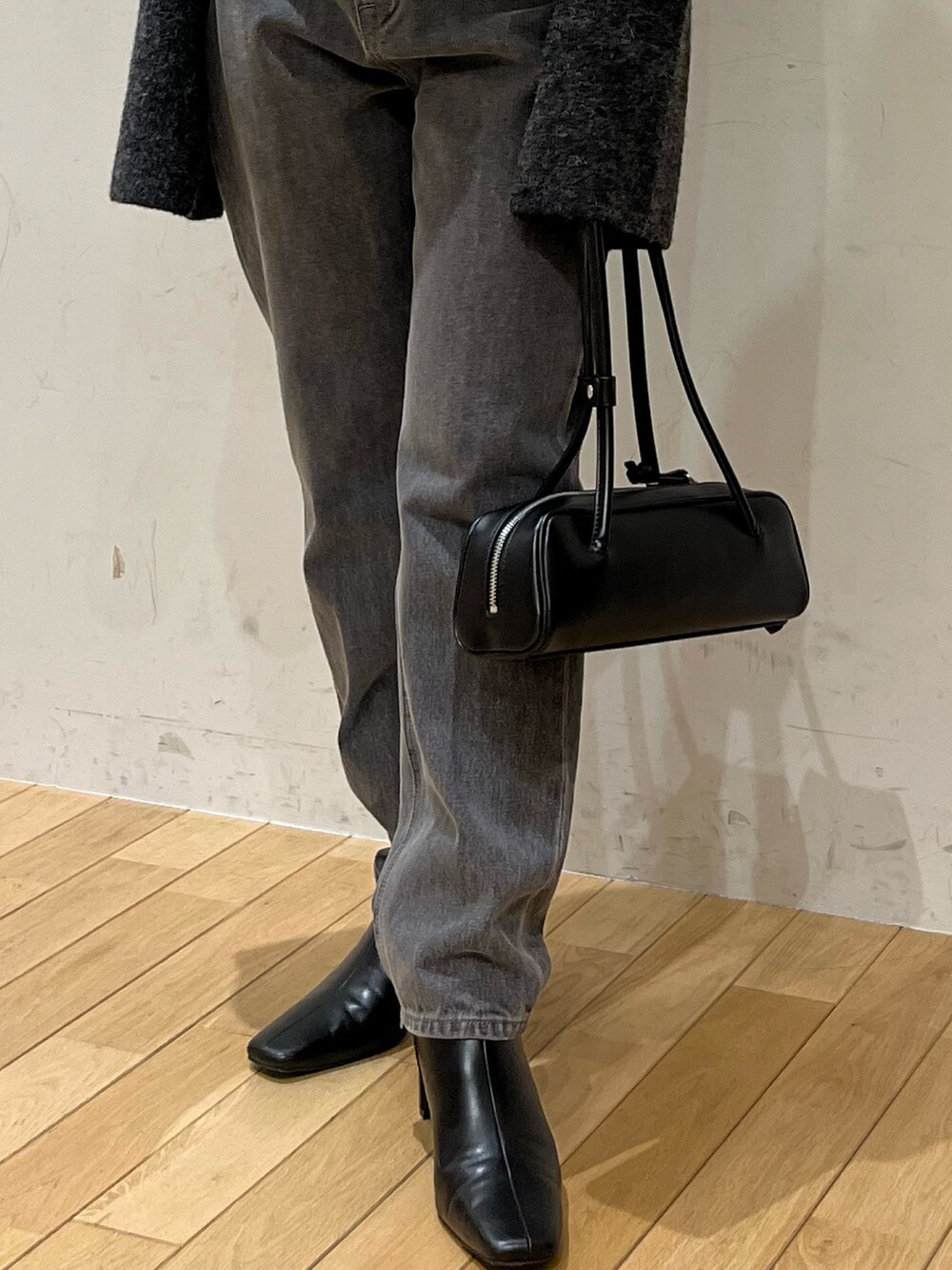 ブラック系のデニムパンツ、グレー系のニット/セーター、ブラック系のショルダーバッグを着用したレディースの秋コーディネートの5枚目の写真