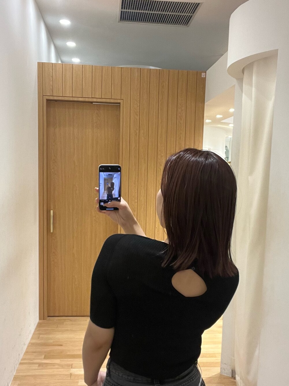 ブラック系のニット/セーター、ブラック系のデニムパンツ、ブラウン系のハンドバッグを着用したレディースの春コーディネートの6枚目の写真