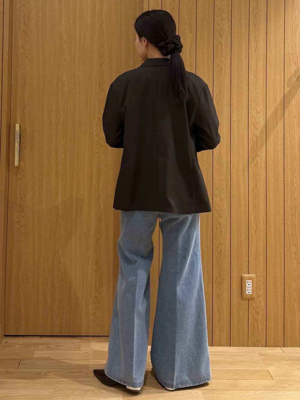 ホワイト系のニット/セーター、ブラウン系のテーラードジャケット、ブルー系のデニムパンツを着用したレディースの春コーディネートの3枚目の写真